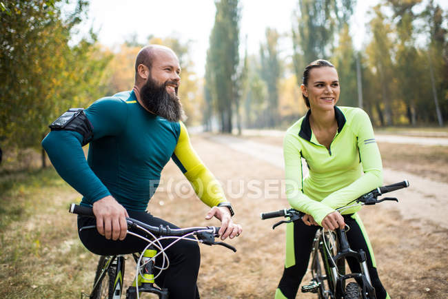 Pareja de ciclistas en el parque de otoño - foto de stock