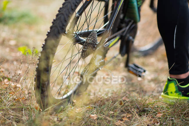 Bicicleta con ciclista en hierba seca - foto de stock