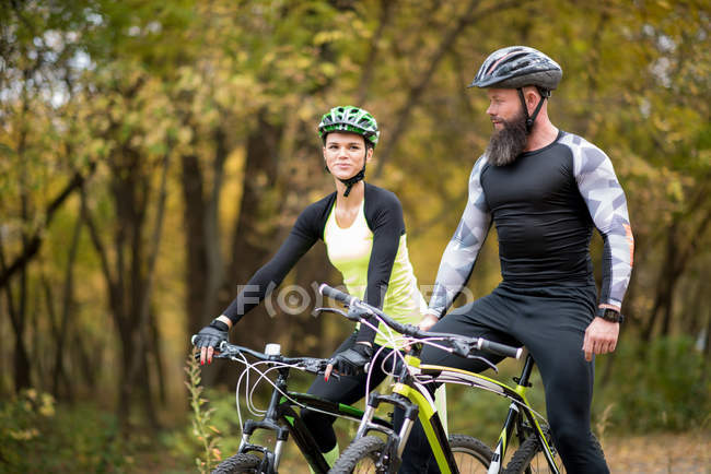 Ciclistas en el parque de otoño - foto de stock