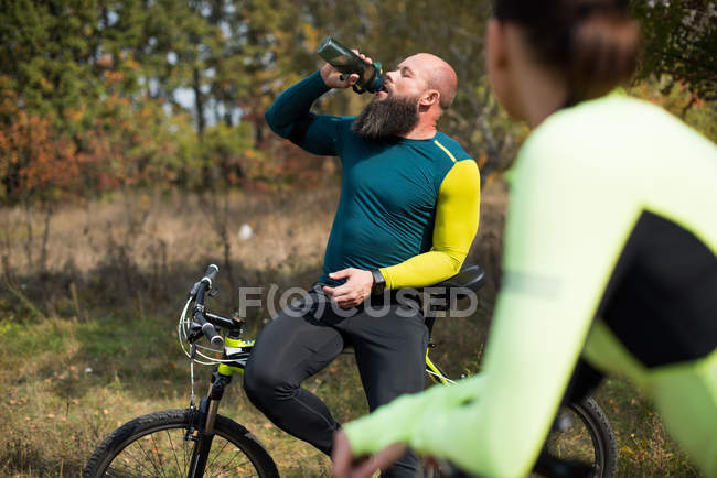 Pareja de ciclistas en el parque de otoño - foto de stock