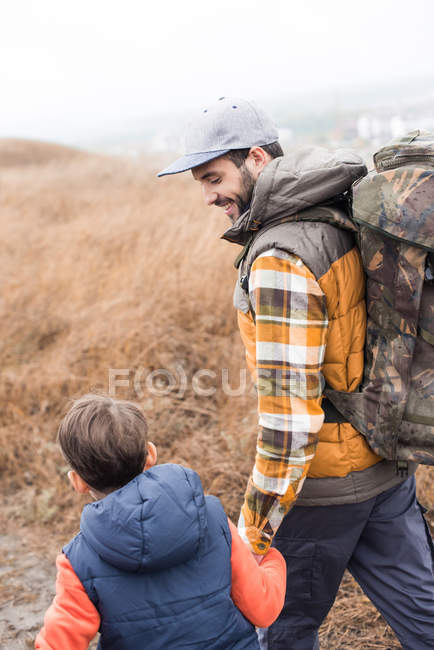 Sorridente padre zaino in spalla con figlio — Foto stock