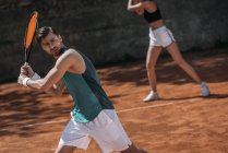 Giovane coppia atletica che gioca a tennis come squadra — Foto stock