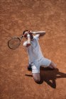 Hochwinkelaufnahme eines Mannes, der auf Knien steht und weint, nachdem er ein Tennismatch verloren hat — Stockfoto
