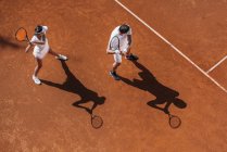 Visão de alto ângulo de jovem casal esportivo jogando tênis como equipe — Fotografia de Stock