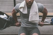 Cropped image of sportsman doing push up from bench — Stock Photo