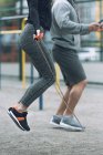 Cropped image of sportsman and sportswoman jumping ropes — Stock Photo