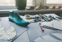 Different tools and shoe last at shoemaker workplace — Stock Photo