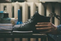 Nahaufnahme des Schuhmachers mit Lederschuhen in der Werkstatt — Stockfoto