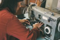 Costurera madura trabajando con máquina de coser eléctrica - foto de stock