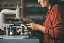 Side view of seamstress sewing leather on electrical machine — Stock Photo