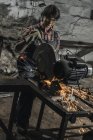 Женщина-сварщик в защитных гуглях с помощью сварочной горелки в мастерской — стоковое фото