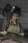 Ritratto di saldatore donna in casco protettivo in officina — Foto stock