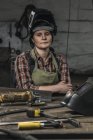 Schweißerin mit Schutzhelm in Werkstatt porträtiert — Stockfoto