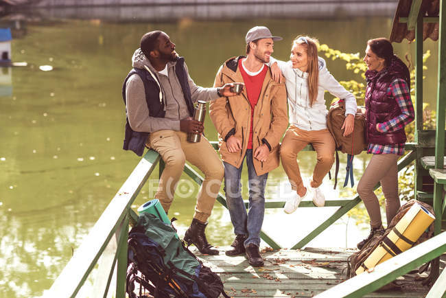 Young travelers resting near river — Stock Photo