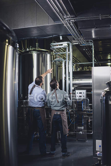 Cervejarias trabalhando com equipamentos industriais — Fotografia de Stock