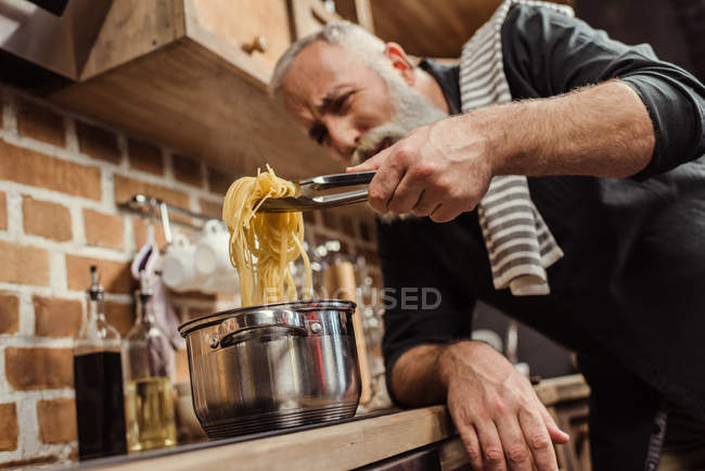 Человек готовит спагетти — стоковое фото