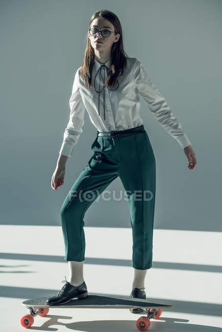 Hipster femme debout sur skateboard — Photo de stock