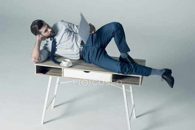Uomo d'affari sdraiato sul tavolo — Foto stock