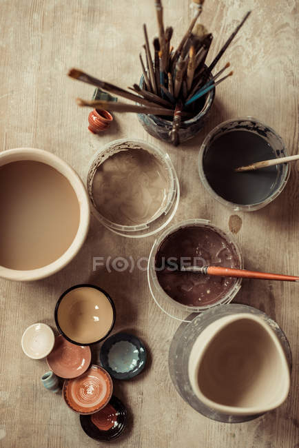 Nahaufnahme von Pinseln mit Töpferwerkzeugen in Schalen auf dem Tisch — Stockfoto