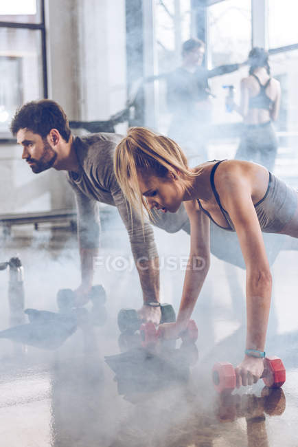 Sporty people exercising in gym — Stock Photo