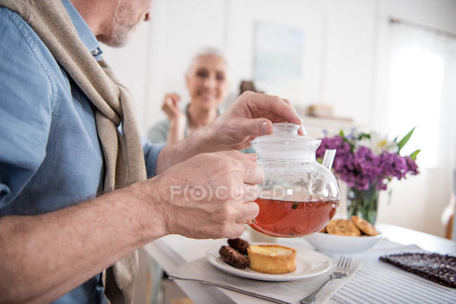 Pareja mayor bebiendo té durante el desayuno - foto de stock