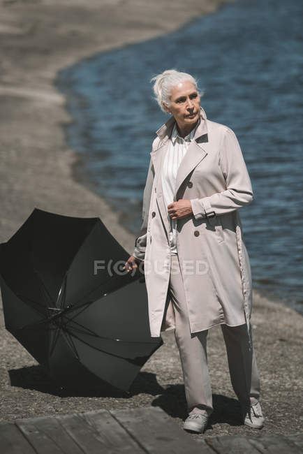 Seniorin mit Regenschirm — Stockfoto