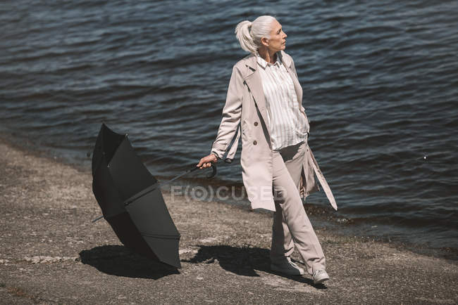 Seniorin mit Regenschirm — Stockfoto