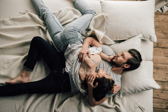 Joven pareja en cama - foto de stock