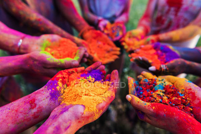 Colorful powder in hands — Stock Photo