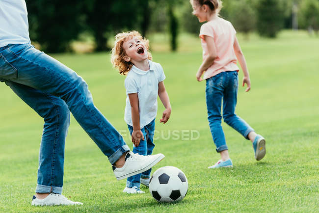 Père avec des enfants jouant au football — Photo de stock