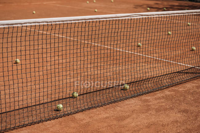 Безладні тенісні м'ячі лежать на корті на відкритому повітрі — стокове фото