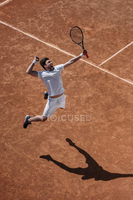 High angle view of athletic tennis player making hit in jump — Stock Photo