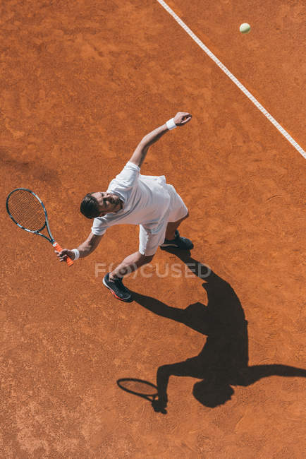 Vista de ángulo alto del hombre haciendo golpe con raqueta de tenis - foto de stock