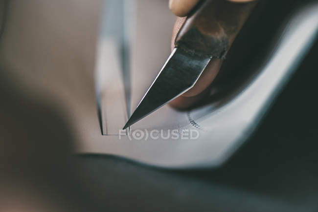 Close-up visão parcial de sapateiro corte único contorno com faca — Fotografia de Stock