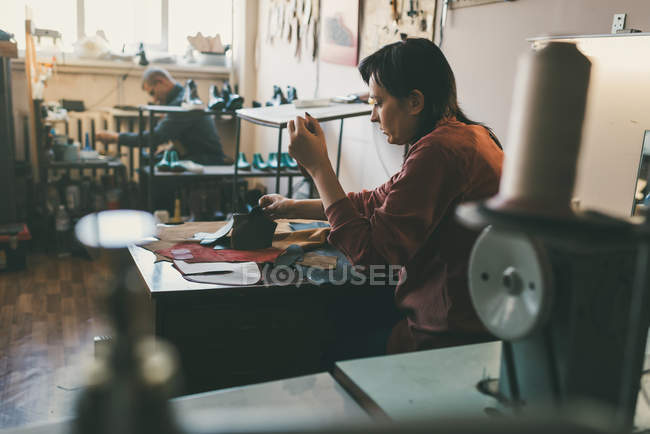 Mature seamstress workign in tailor shop — Stock Photo