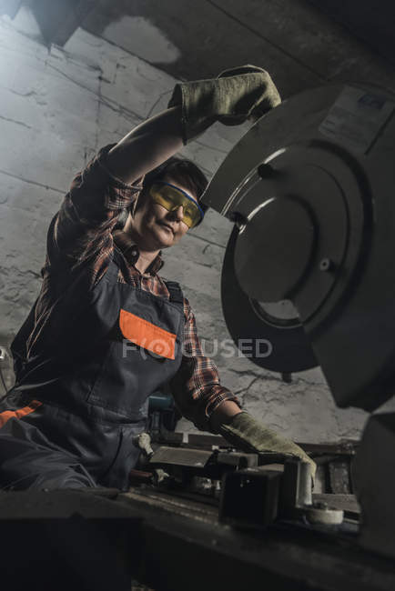Schweißerin in Schutzbrille mit Schweißbrenner in Werkstatt — Stockfoto