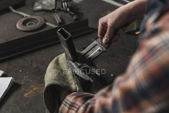 Partial view of welder working on peace of metal in workshop — Stock Photo
