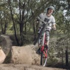 Гонщик, стоящий на одном велосипедном колесе в лесу — стоковое фото