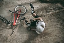 Велосипедист падает с велосипеда в шлеме — стоковое фото