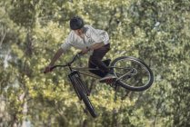 Спортсмен стрибки з велосипед з дерева на розмитість фону — стокове фото