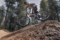 Bottom view of cyclist riding mountain bike on track in forest — Stock Photo