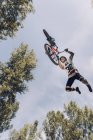 Vista dal basso di sportsman jumping con bici — Foto stock
