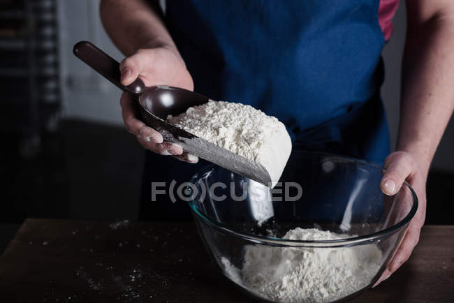 Panettiere setacciando farina — Foto stock