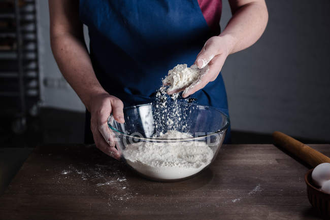 Baker peneirando farinha — Fotografia de Stock